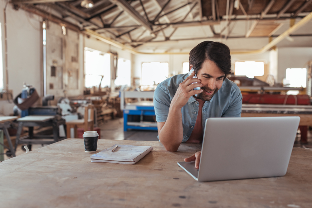 Tradesman on laptop and phone