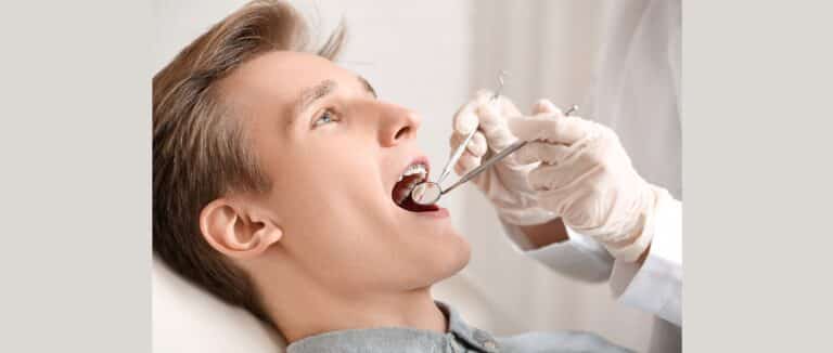 Orthodontist checks mouth of man with braces.