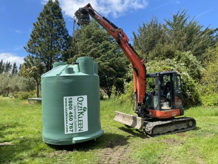 digger moving a septic tank